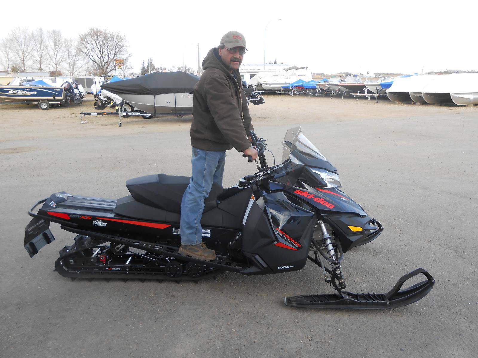 Man standing on a black Ski-Doo Renegade snowmobile