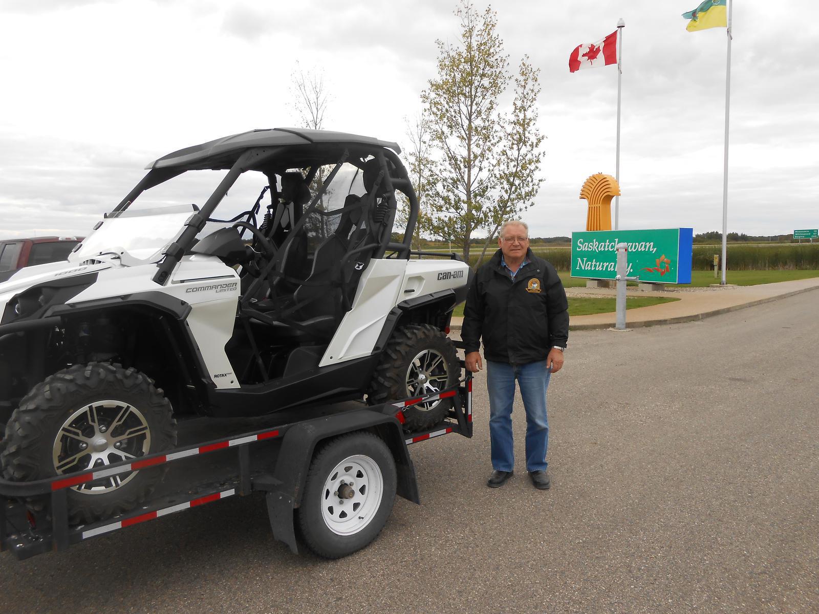Man standing beside a white Can-Am Commander UTV