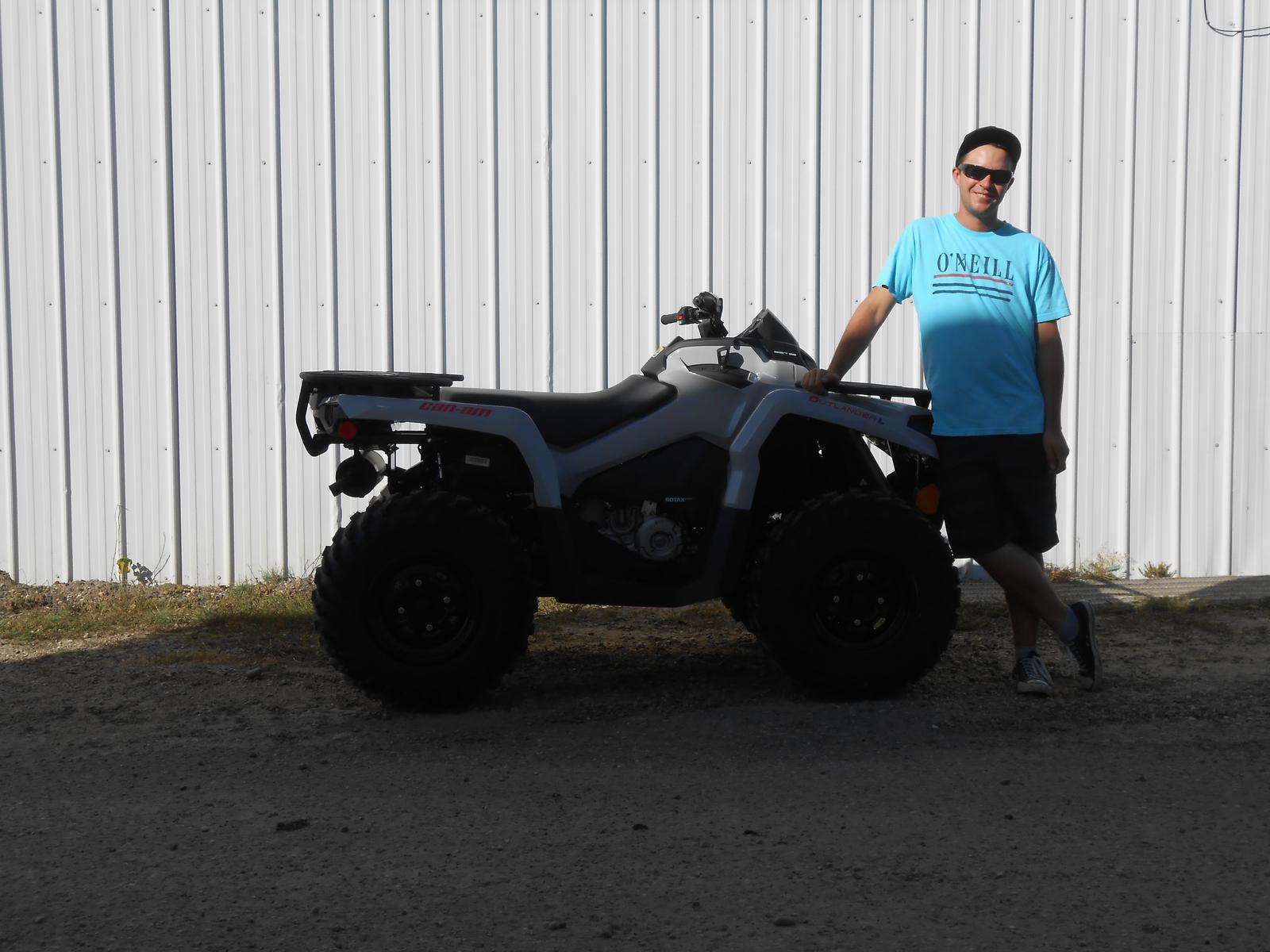 Man posing beside a gray Can-Am Outlander ATV