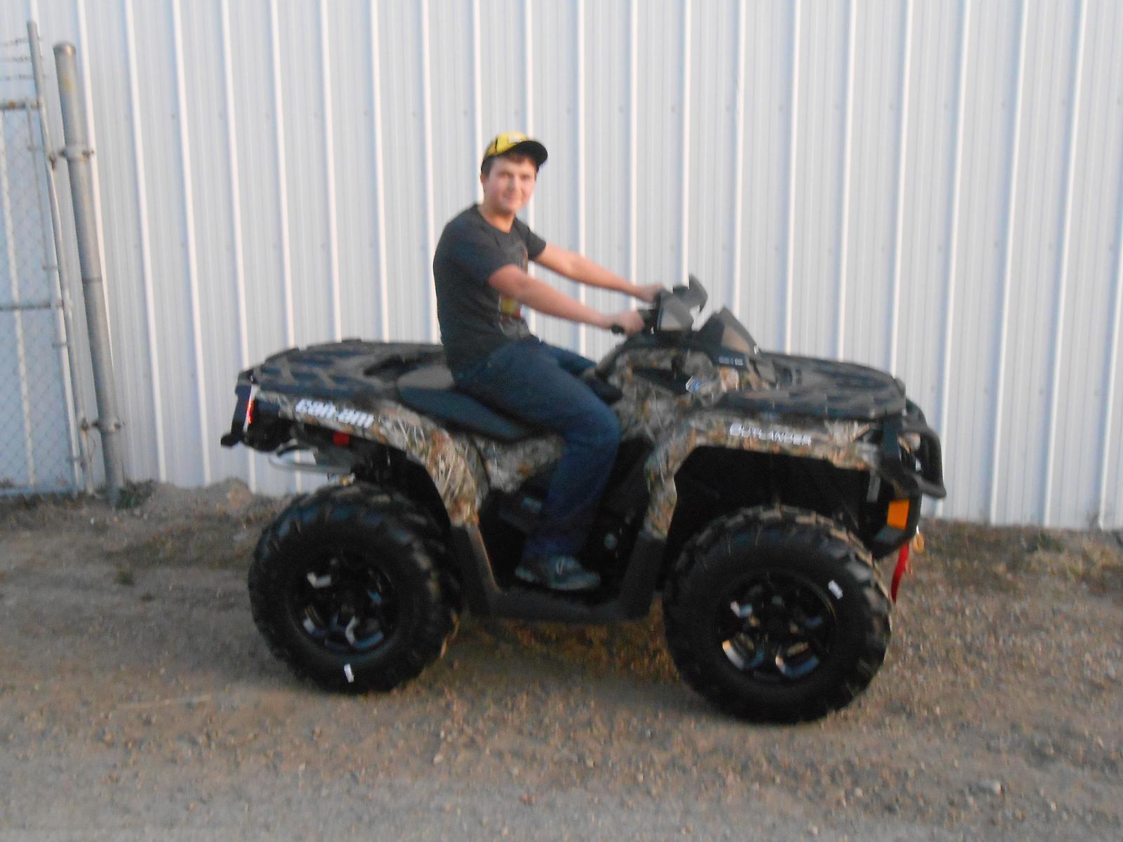 Man seated in a camo Can-Am Outlander ATV