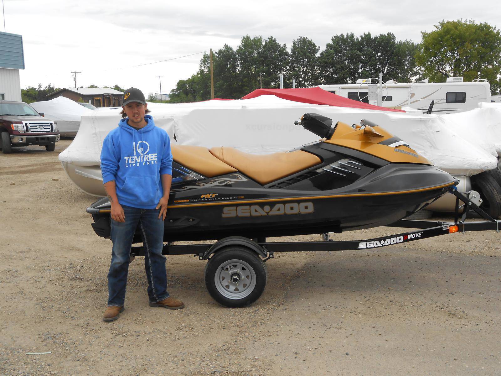 Man standing in front of a yellow Sea-Doo RXT watercraft